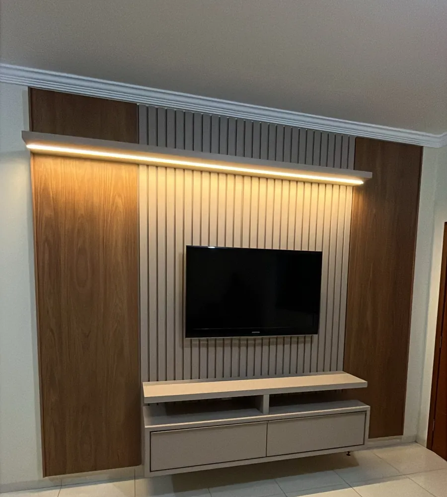 Painel de TV ripado com nichos amadeirados e iluminação em LED